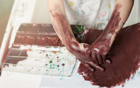 Dirty with paint kid hands on rable background above viewの写真素材