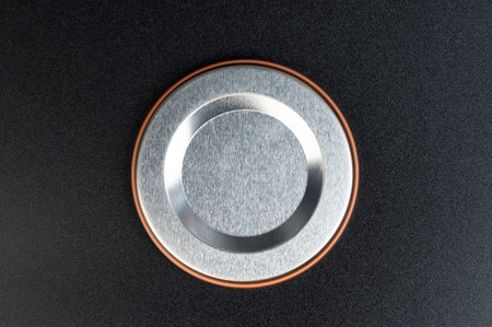 Metal shiny circle on black matte background close up view