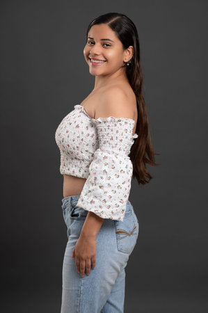 Portrait of hispanic smiling young woman side profile view isolated on studio background