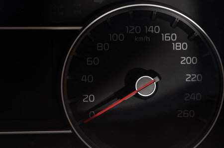 Car speed meter gauge on dark background close up view