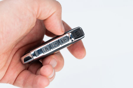 Control keys on car key on human hand isolated close up view