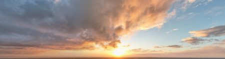Panorama of dramatic sunset sky with fluffy clouds