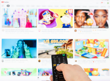 New york, USA - February 21, 2023: Select video on youtube stream service on tv with remote control in handのeditorial素材
