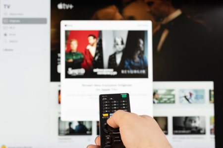 New york, USA - February 21, 2023: Select video on Apple  TV plus  stream service on tv with remote control in handのeditorial素材