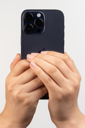 New york, USA - February 24, 2023: Taking photo with Iphone 14 pro maxisolated on white studio backgroundのeditorial素材