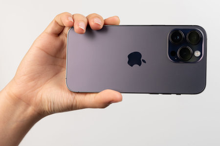 New york, USA - February 24, 2023:Close up of iphone 14 pro max in hand isolated on white studio...