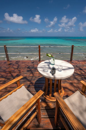 Wooden terrace with table and chair on blue sea backgroundの写真素材