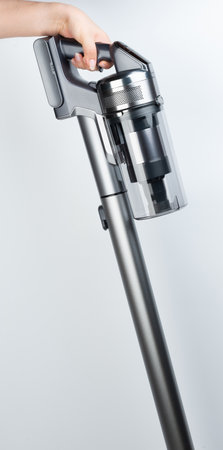 Hand hold cordless vacuum cleaner isolated on white studio backgroundの写真素材