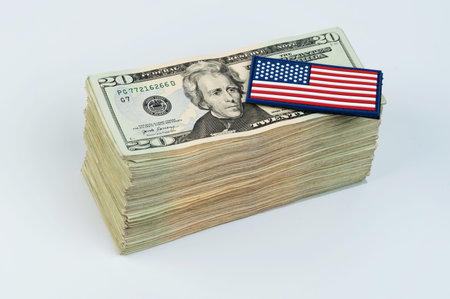 American flag on pile of 20 dollar banknote isolated on white studio background