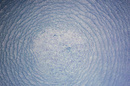 Blue water background with circle ripple waves above top view