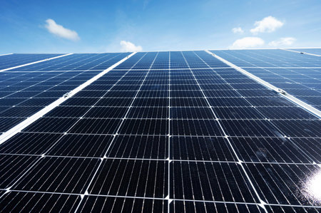 Clean solar panel array on blue sky background with small clouds