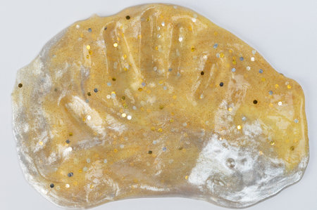 Human palm trace on golden color slime service isolated on white studio background
