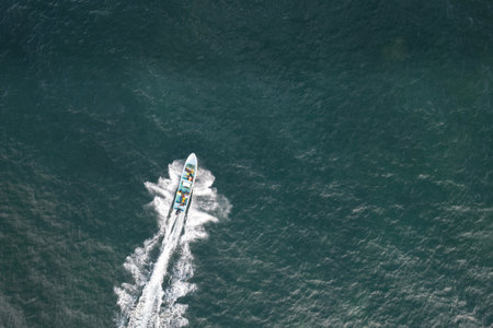 Small fishing boat moving at sea above top drone viewの写真素材