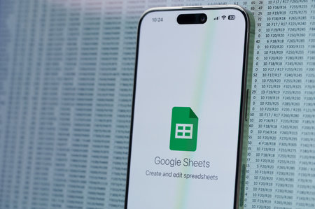 New York, USA - February 22, 2024: Work on google Sheets  in smartphone on data background close up viewのeditorial素材