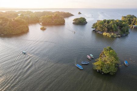 Boats next to small island aerial drone view on sunset time