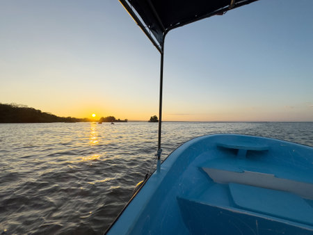 Sunset on lake boat tour. Empty blue boat with roof in tropical backgroundの写真素材