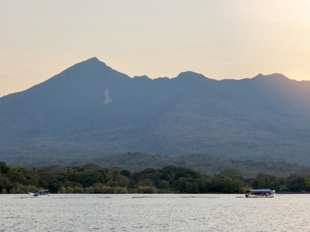 Mombacho volcano in sunset light background with boats in frontの写真素材