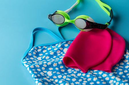 Colorful swimming accessories on blue studio background