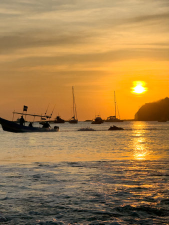 Sunset over boats in ocean bay with low sun backgroundの写真素材