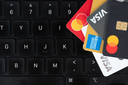 New York, USA - July 5, 2024: Paying online with credit cards laying on top of black laptop keyboard