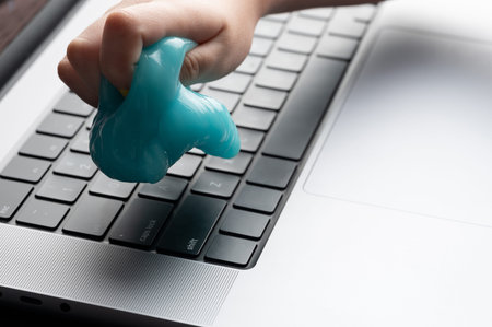 Dust cleaner of laptop keybaord in hand close up viewの写真素材