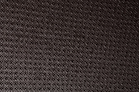 Clean perforated brown leather background macro close up view