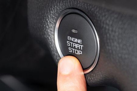 Finger push start stop engine button close up view