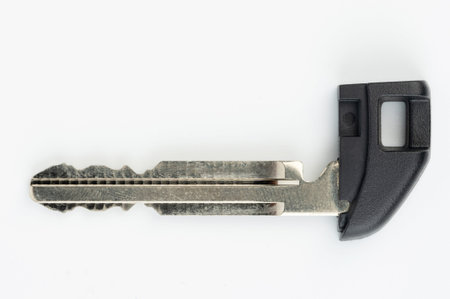 Small steel metal car key isolated on white studio background
