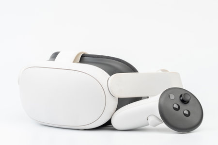 Virtual reality headset paired with controller rests on smooth surface, showcasing sleek, modern technology.の写真素材
