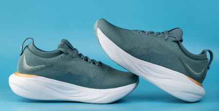 Trainer sport shoes side view isolated on blue studio backgroundの写真素材