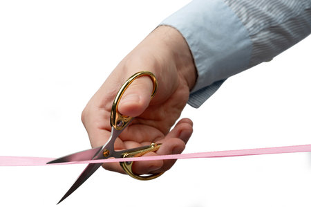 Cutting ribbon with scissors in hands close up view isolatedの写真素材