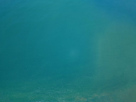 Abstract ocean water surface with ripples above top drone viewの写真素材