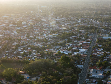 Panoramic view captures Jinotepe town at sunset, showcasing houses, roads, and greenery in the surrounding area.の写真素材