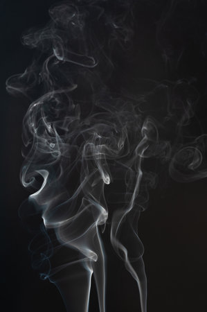 Smoke flow swirls isolated on black studio backgroundの写真素材