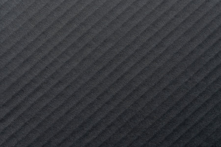 Textured surface with diagonal lines forms elegant pattern under natural light, creating depth and contrast.の写真素材