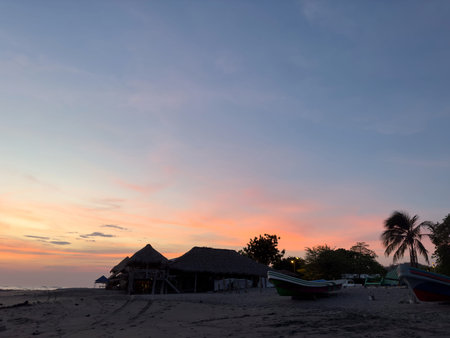 Topical beach landscape with bungalow and boat at dusk timeの写真素材