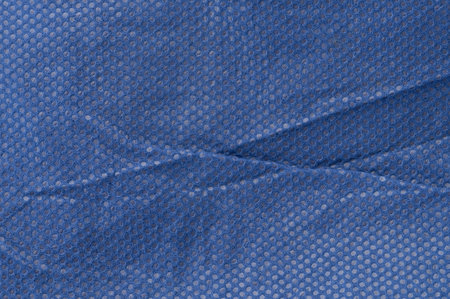 Close-up view of textured blue fabric with mesh pattern, ideal for creative design applications.の写真素材