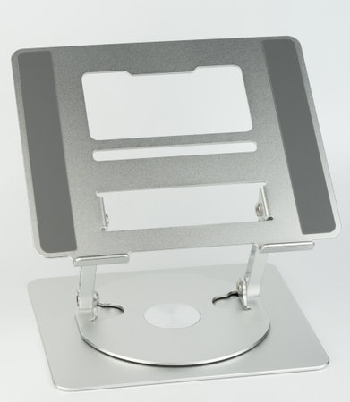 Sleek metal laptop stand features adjustable height and angle, promoting good posture while working at a desk.の写真素材