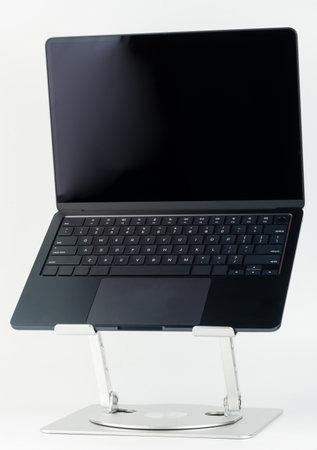 mMinimalistic laptop positioned on stylish stand, emphasizing its sleek design and features in bright setting.の写真素材