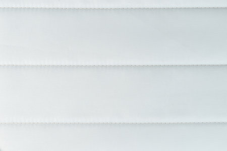 Soft white fabric features prominent stitching, creating sleek and refined surface ideal for design projects.の写真素材