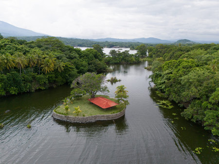Channel in lake with small island for events with green grass and red roofの写真素材