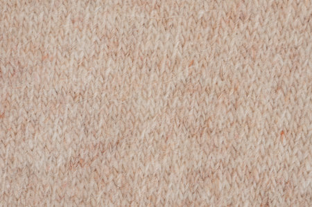 Close-up view shows knitted fabric with soft texture in warm beige tones, perfect for winter clothing and accessories.の写真素材