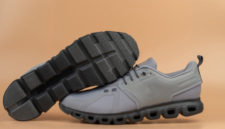 Grey athletic shoes stand out on plain background, highlighting stylish design and functionality for active life.の写真素材
