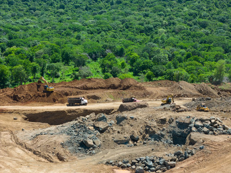 Stone quarry machinery on green natural background aerial drone view