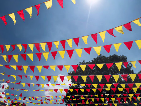 Red and yellow flag on blue sky background on party holiday eventの写真素材