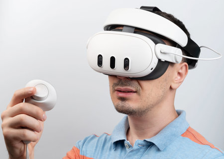 Man using virtual reality headset with controller isolated on white studio background