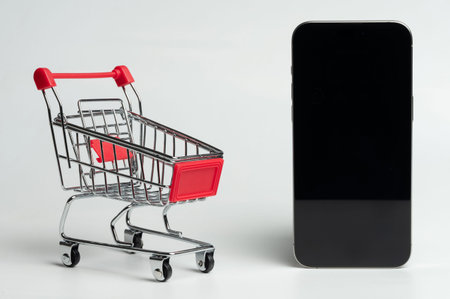 Smartphone with shopping cart isolated on white studio backgroundの写真素材