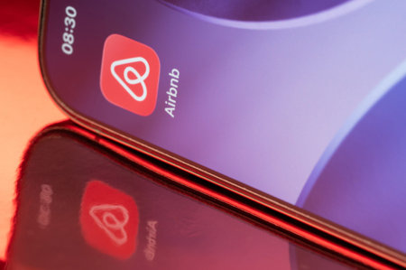 New York, USA - February 23, 2026: Airbnb icon application on smartphone screen close up with pink reflection on pink backgroundのeditorial素材