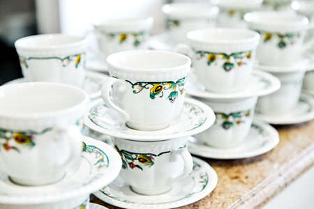 cups and saucers in a row on the tableの写真素材