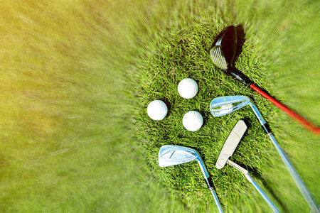 golf clubs and balls on grass background